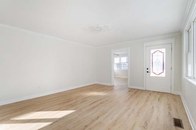 foyer with crown molding and light hardwood / wood-style floors