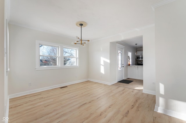 entrance foyer featuring ornamental molding, a chandelier, and light hardwood / wood-style flooring