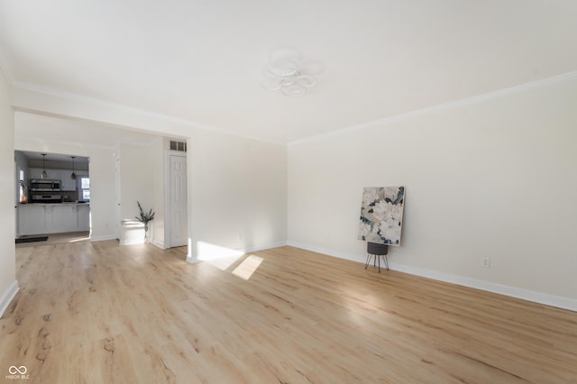 unfurnished living room featuring ornamental molding and light wood-type flooring