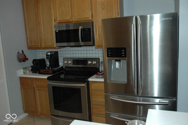 kitchen featuring backsplash, light tile patterned floors, and stainless steel appliances