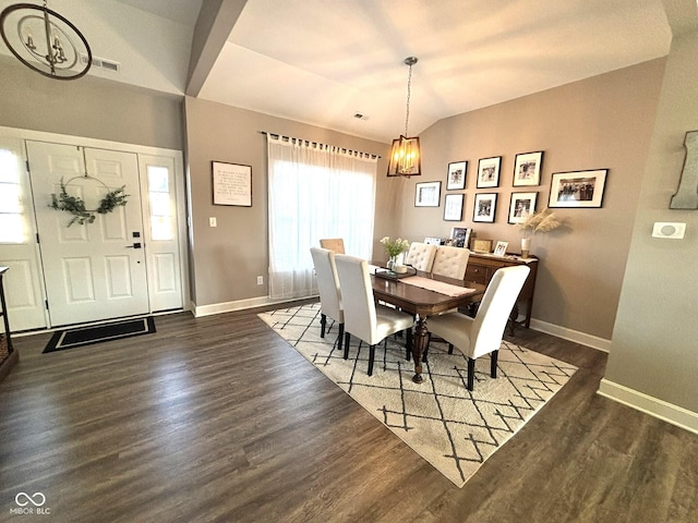 dining room featuring lofted ceiling, dark hardwood / wood-style floors, and an inviting chandelier