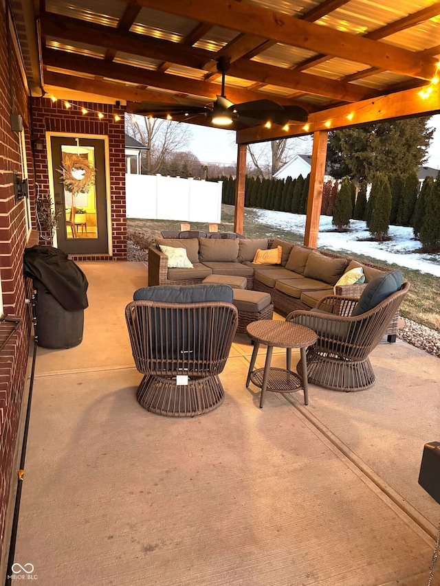 snow covered patio featuring fence and an outdoor hangout area