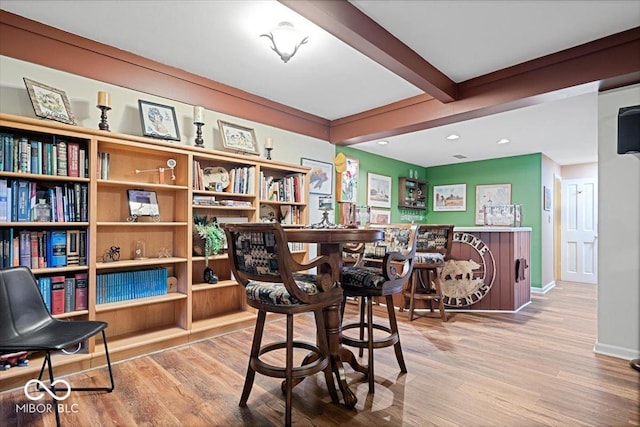 bar with hardwood / wood-style floors and beam ceiling