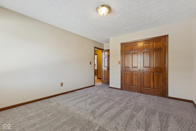 unfurnished bedroom with a closet, a textured ceiling, and carpet