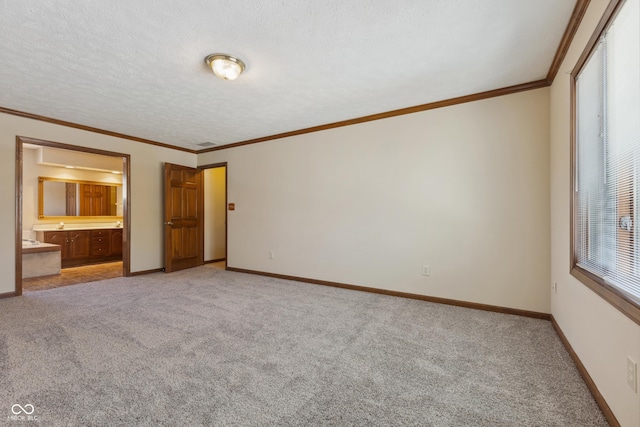 unfurnished bedroom with crown molding, ensuite bathroom, a textured ceiling, and carpet flooring