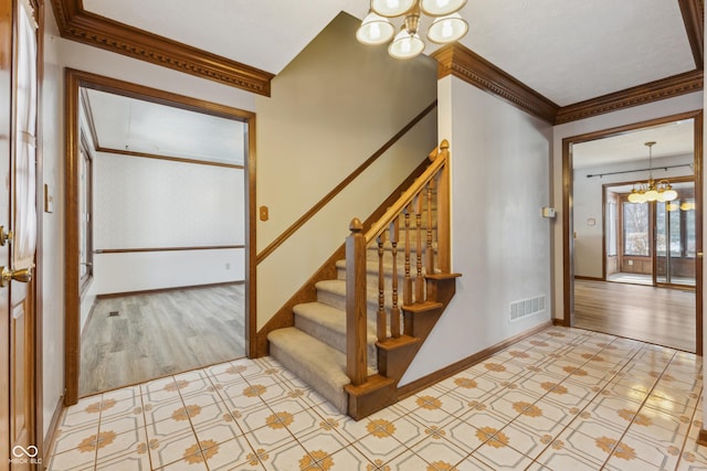 staircase featuring ornamental molding, hardwood / wood-style floors, and a notable chandelier