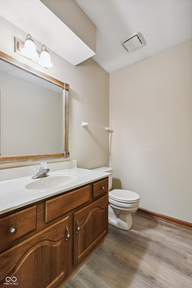 bathroom with vanity, hardwood / wood-style floors, and toilet