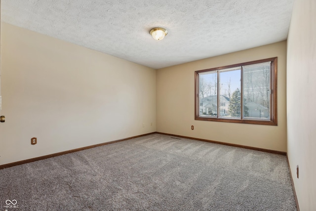 unfurnished room featuring a textured ceiling and carpet