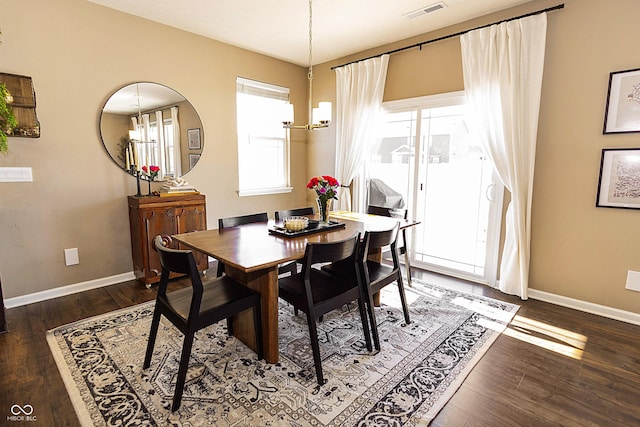 dining space with a notable chandelier and dark hardwood / wood-style floors