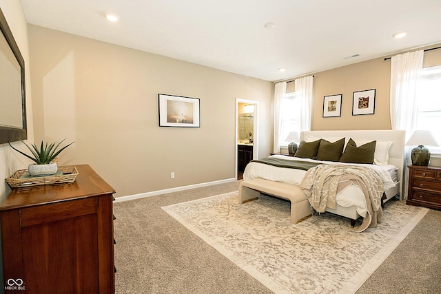 carpeted bedroom featuring ensuite bath