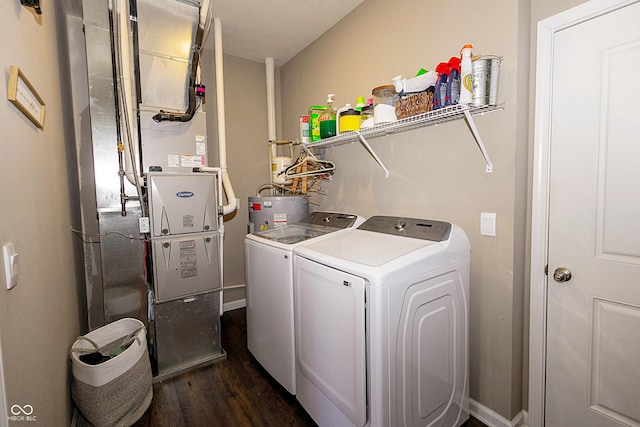 laundry area featuring dark hardwood / wood-style floors, electric water heater, and independent washer and dryer