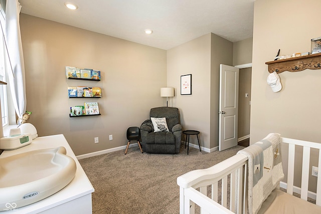 bedroom featuring a nursery area, carpet flooring, and sink