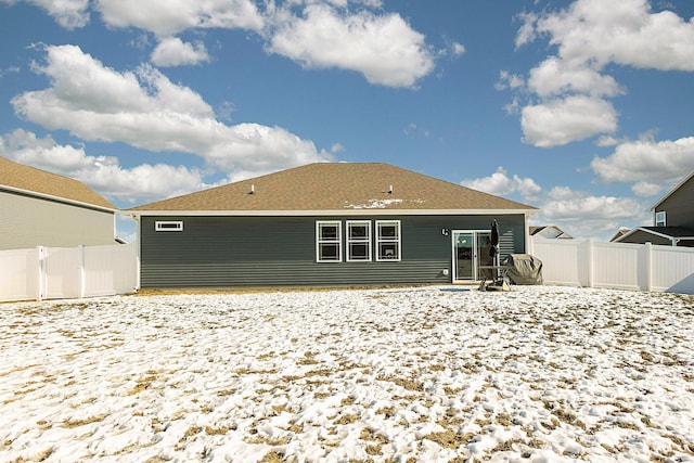 view of snow covered rear of property