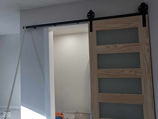 interior space featuring a barn door and a textured ceiling