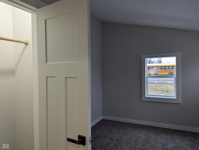 carpeted empty room with a textured ceiling