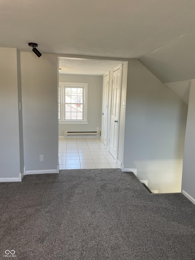 interior space featuring light carpet, vaulted ceiling, and baseboard heating