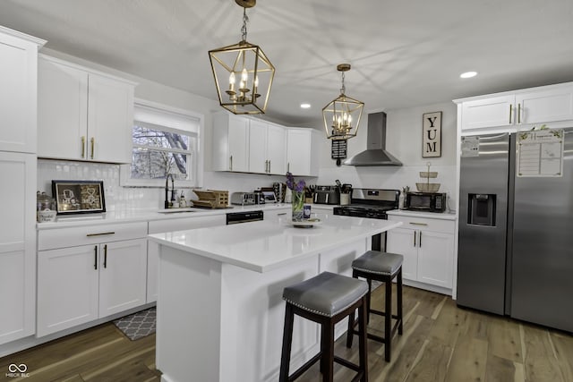 kitchen featuring white cabinets, black appliances, a center island, and wall chimney exhaust hood