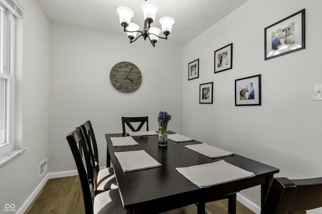 dining room featuring hardwood / wood-style flooring and an inviting chandelier