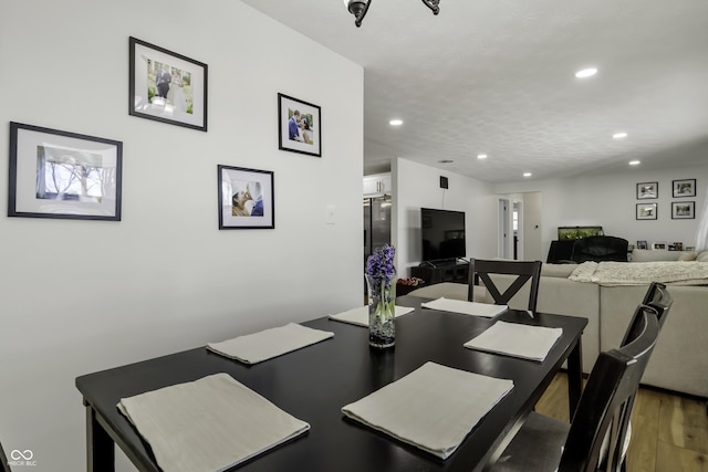 dining area with hardwood / wood-style flooring and a textured ceiling