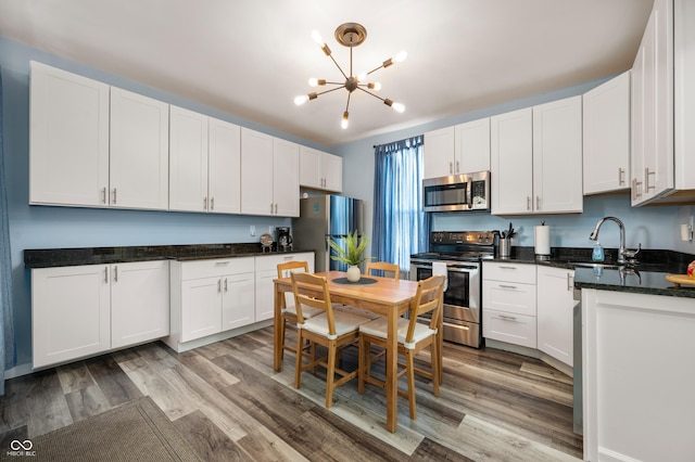1130 S Senate Ave, Indianapolis, IN 46225 - kitchen featuring appliances with stainless steel finishes, white cabinets, and light hardwood / wood-style flooring