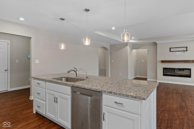 kitchen featuring pendant lighting, white cabinetry, sink, stainless steel dishwasher, and light stone counters