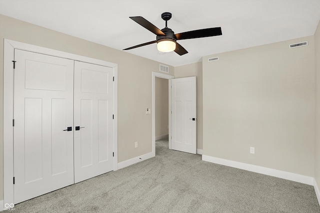 unfurnished bedroom with light colored carpet, a closet, and ceiling fan