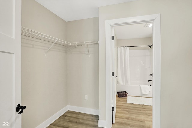 walk in closet with wood-type flooring