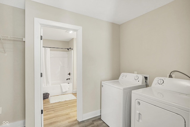 laundry room featuring hardwood / wood-style floors and washer and dryer