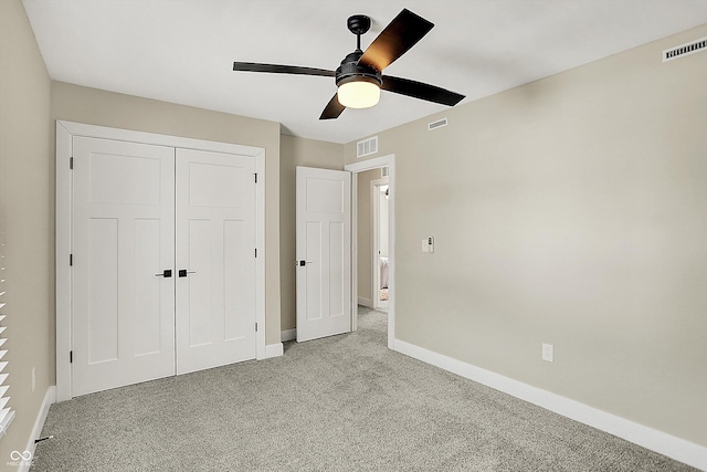 unfurnished bedroom featuring light colored carpet, ceiling fan, and a closet