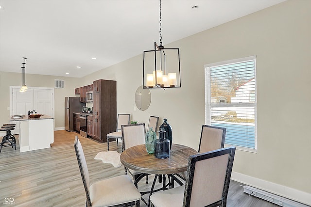 dining area featuring an inviting chandelier and light hardwood / wood-style floors