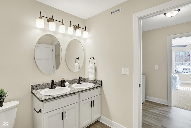 bathroom featuring vanity, hardwood / wood-style floors, and toilet