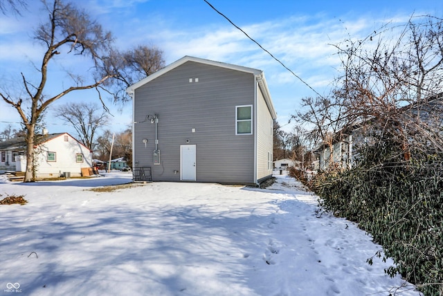 view of snow covered rear of property