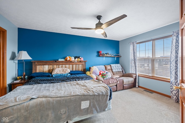 bedroom featuring ceiling fan, carpet floors, and a textured ceiling