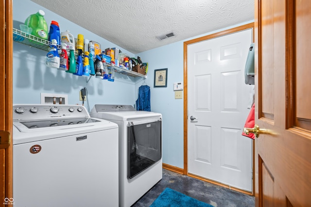 washroom with washing machine and clothes dryer and a textured ceiling