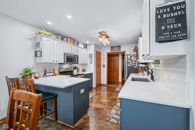 kitchen with sink, white cabinetry, stainless steel appliances, tasteful backsplash, and kitchen peninsula