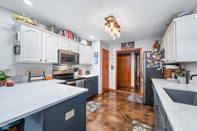 kitchen featuring stainless steel appliances, white cabinetry, sink, and light stone counters