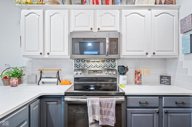 kitchen with backsplash, appliances with stainless steel finishes, gray cabinets, and white cabinets