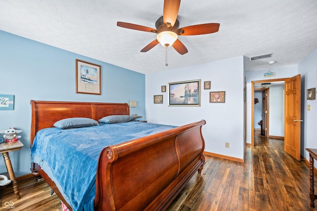 bedroom with ceiling fan, dark hardwood / wood-style floors, and a textured ceiling