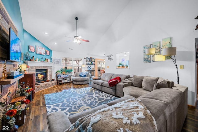 living room featuring ceiling fan, high vaulted ceiling, dark wood-type flooring, and a fireplace