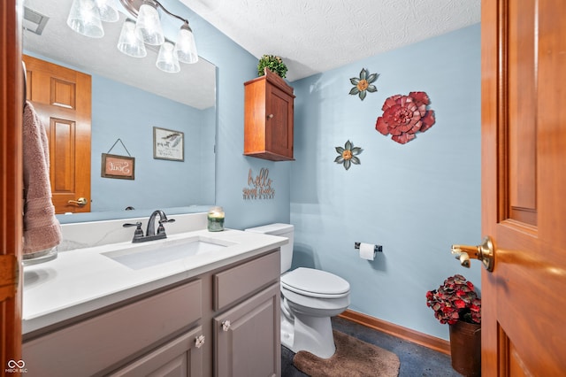 bathroom with vanity, a textured ceiling, and toilet