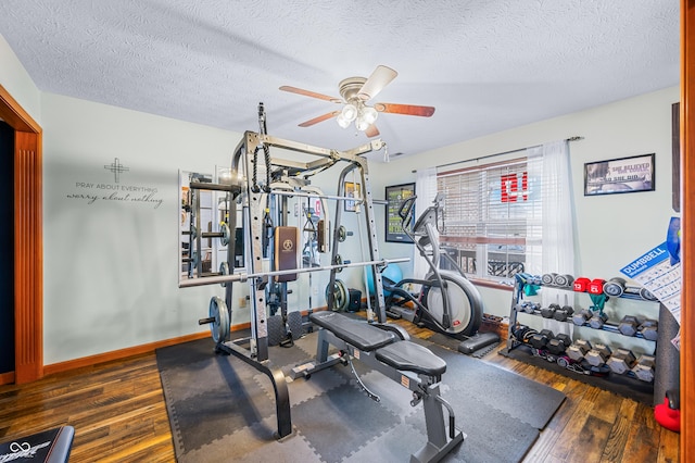 exercise room with ceiling fan, dark hardwood / wood-style floors, and a textured ceiling