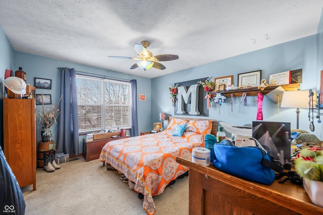 bedroom featuring ceiling fan, light carpet, and a textured ceiling