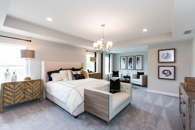 bedroom with a tray ceiling, carpet flooring, and a notable chandelier