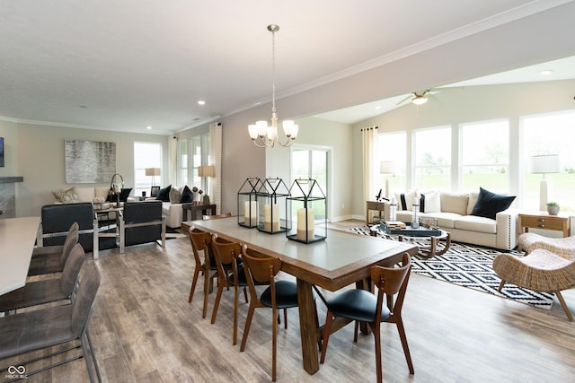 dining area featuring lofted ceiling, hardwood / wood-style floors, ornamental molding, and a chandelier