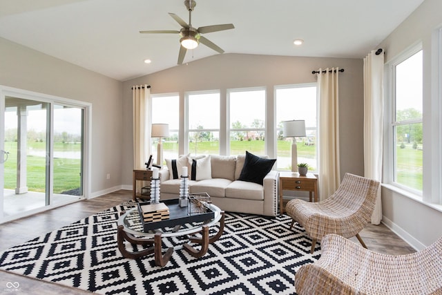 living room featuring lofted ceiling, a wealth of natural light, ceiling fan, and light hardwood / wood-style flooring