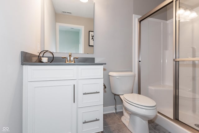 bathroom featuring vanity, toilet, a shower with shower door, and tile patterned flooring