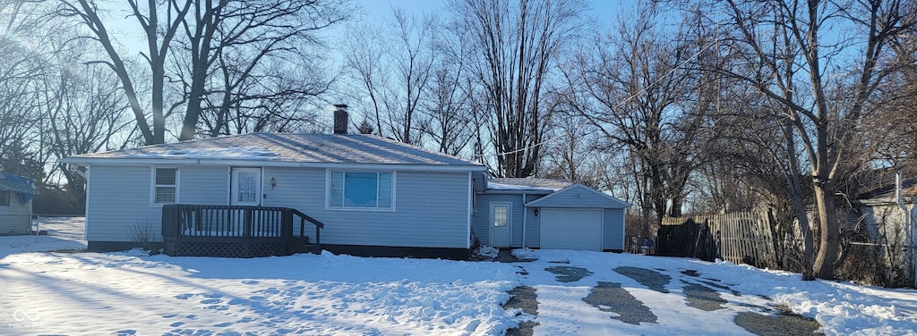 view of front of home featuring a garage and an outbuilding