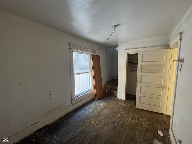 unfurnished bedroom with dark hardwood / wood-style flooring and a closet