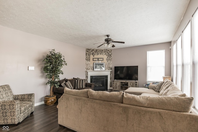 living room with ceiling fan, dark hardwood / wood-style floors, and a textured ceiling