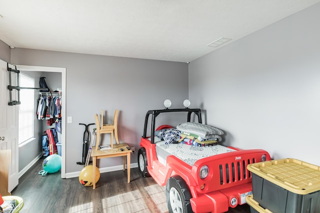 bedroom with dark hardwood / wood-style flooring and a closet